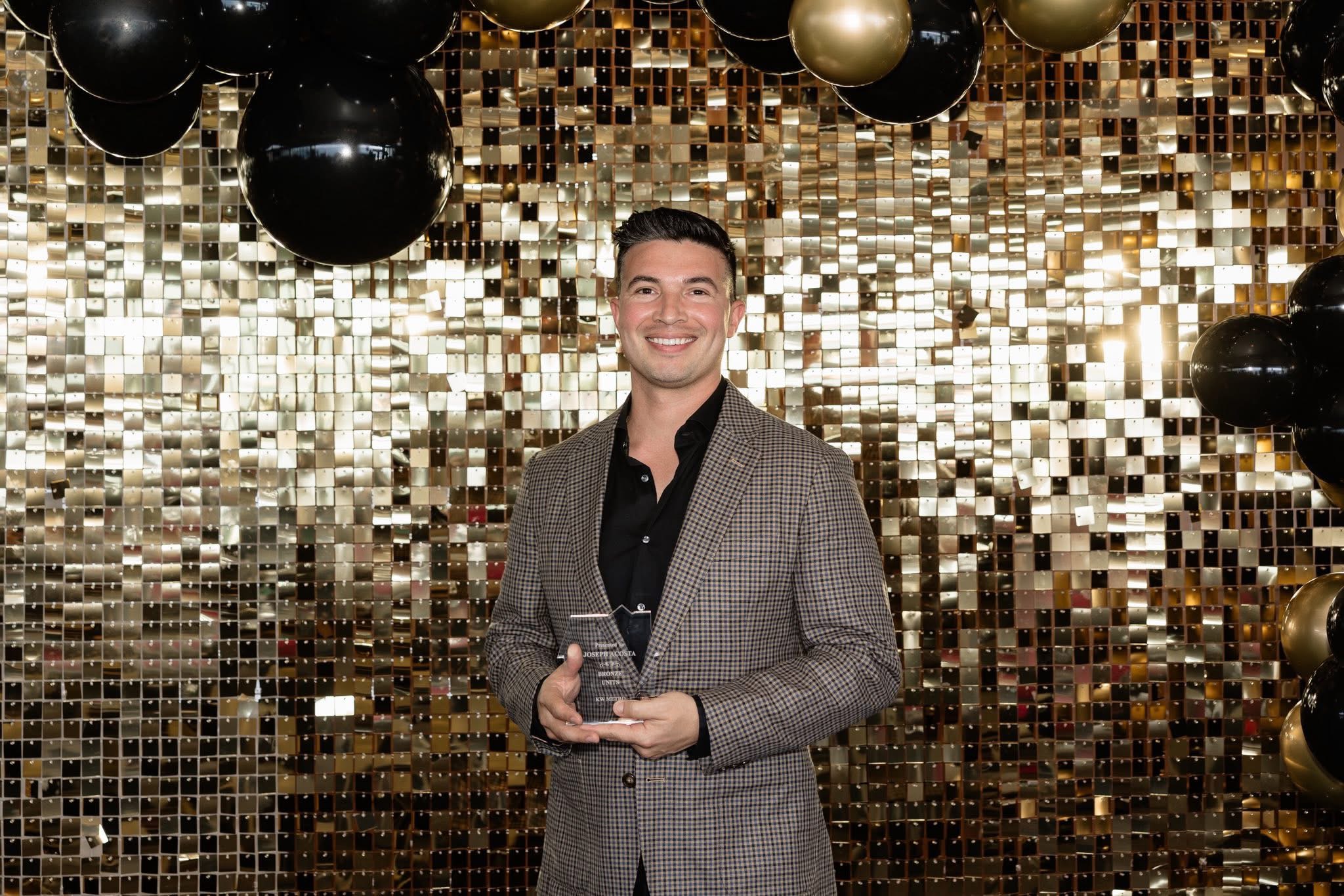 Joseph Acosta holding an award